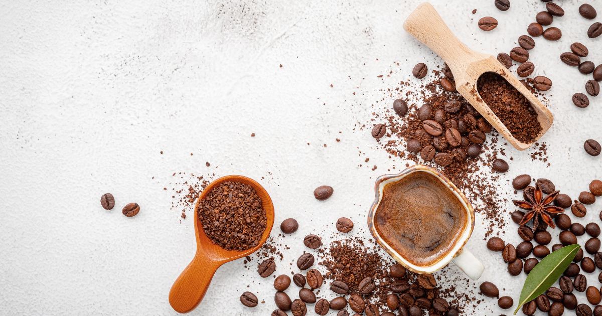 Different coffee beans, ground to different consistencies, sitting on a table.