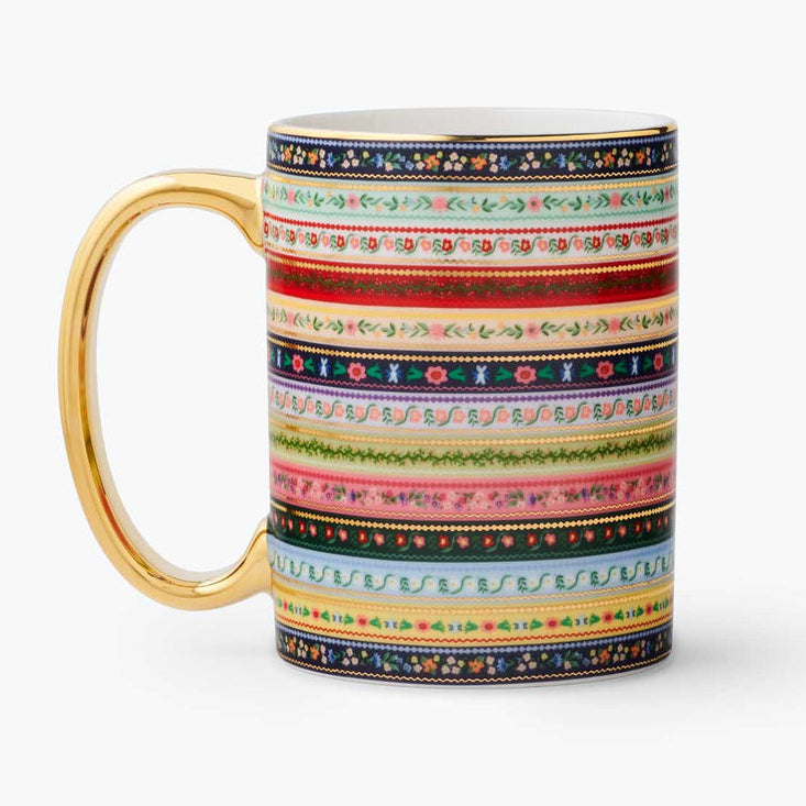Colorful patterned mug with a gold handle on a white background