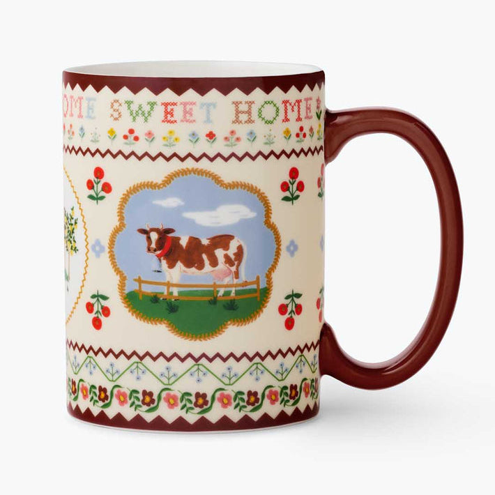 Mug with cow design and 'Home Sweet Home' text on a white background