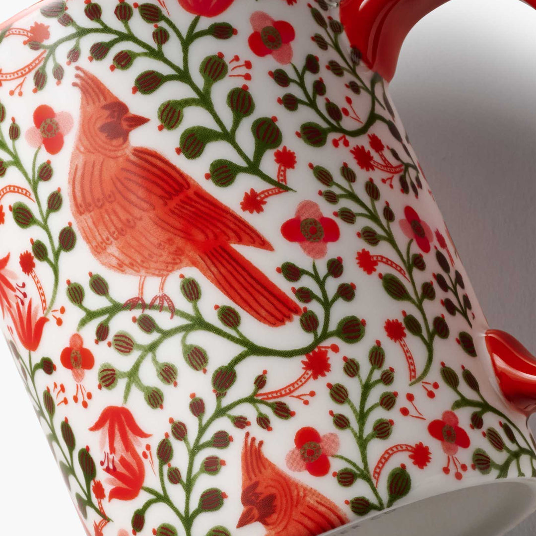 Tea pot with red cardinal and floral design on a white background